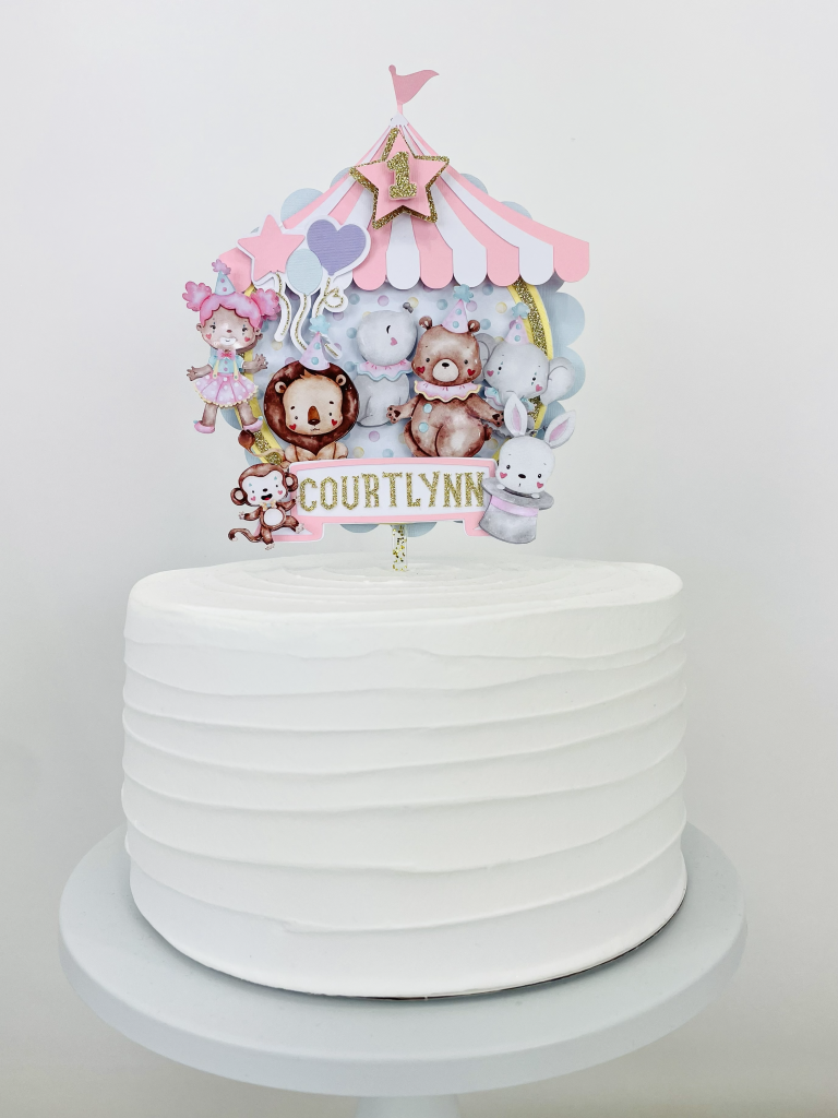 Circus ONE first birthday cake topper with pastel carnival theme on white cake stand