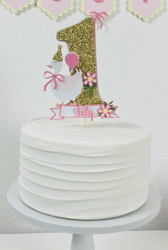Pink Silly Goose first birthday cake topper styled on cake for a simple at-home celebration