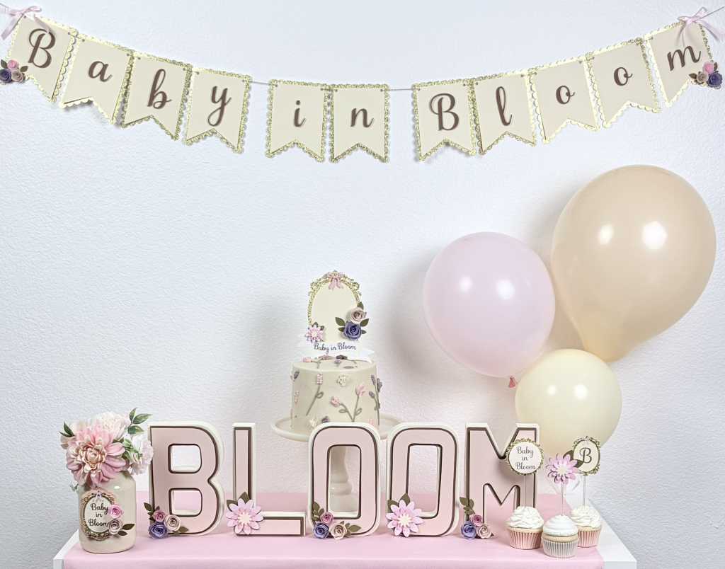 Baby in Bloom baby shower decorations with floral banner, pastel balloons, and elegant table setup