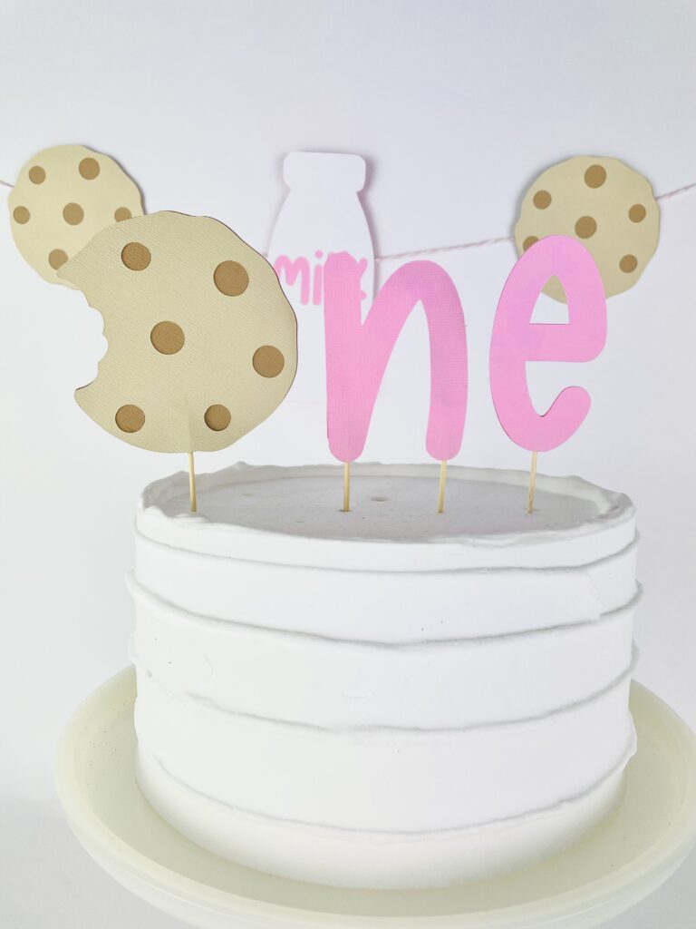 Close up image of pink cookies and milk birthday cake topper